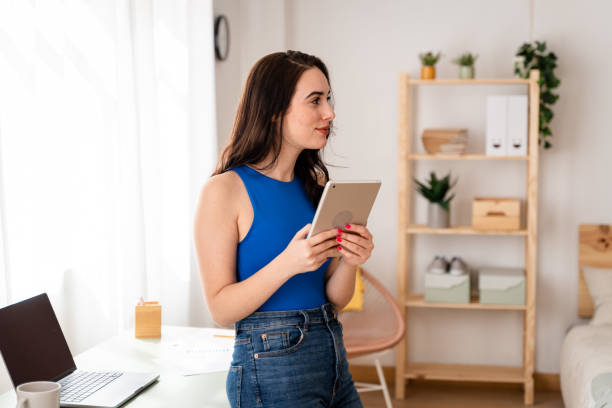 istock Woman working remotely looking at emails on digital tablet. 1487695157