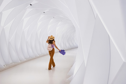a girl walks along the passage leading from the metro station in futuristic light spaceship style