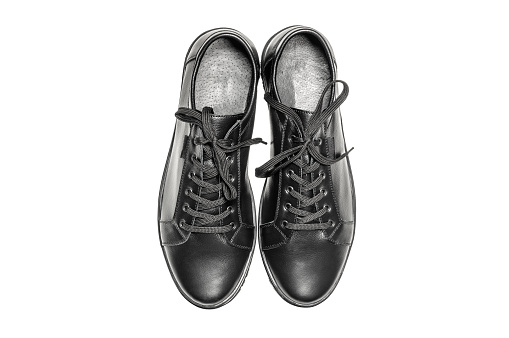 Top view of a pair of black leather sneakers isolated on white background