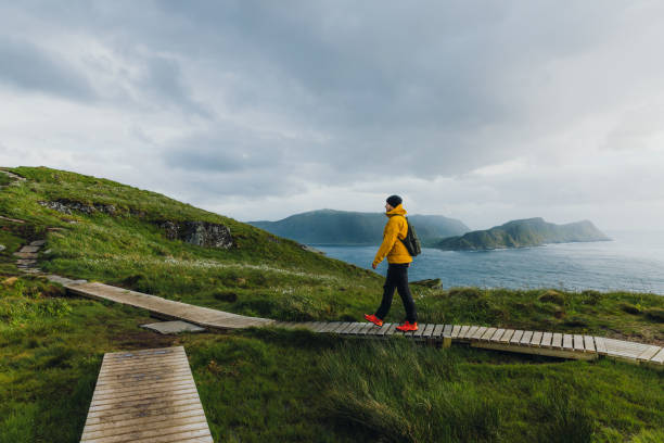 istock Man backpacker hiking on footpath on scenic Runde island with ocean view in Norway 1487700416
