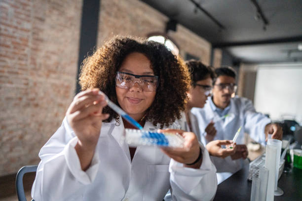 Young woman doing experiment during chemistry class
