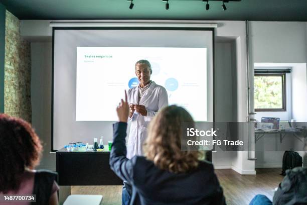Teacher Doing A Presentation And Student Raising Hand During Chemistry Class Stock Photo - Download Image Now