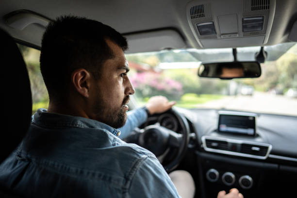 istock Rear view of a young man driving a car 1487703650