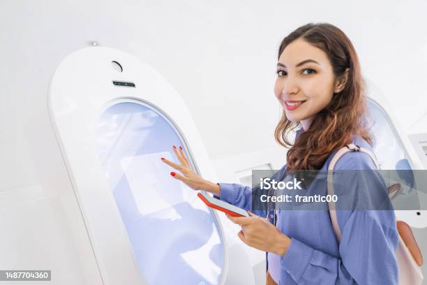 A Female Customer Uses A Terminal Or Selfservice Kiosk To Order At A Fast Food Restaurant Or Buy Tickets To Museum Or Transport Stock Photo - Download Image Now