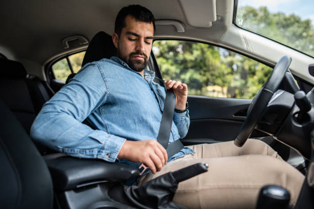 istock Young man fastening seat belt in a car 1487704362