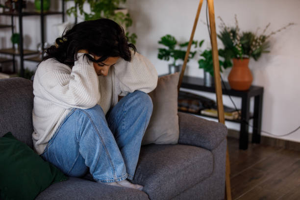 istock Distraught young woman sitting with head in hands, struggling with negative emotions 1487705872