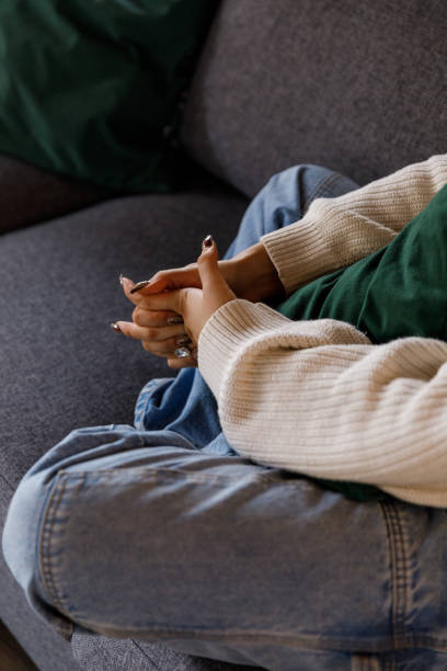 Young woman struggling with negative emotions and anxiously cracking her knuckles stock photo