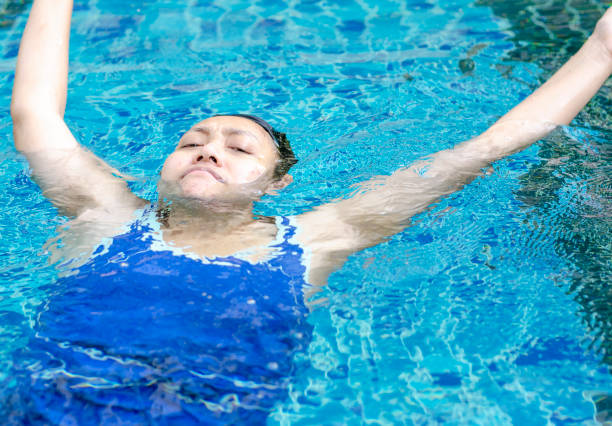 istock Asian woman floating in swimming pool 1487706138