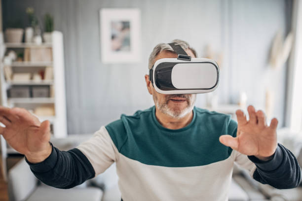 istock Elderly man enjoying with VR glasses at home 1487706342