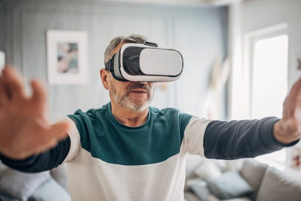 istock Elderly man enjoying with VR glasses at home 1487706442