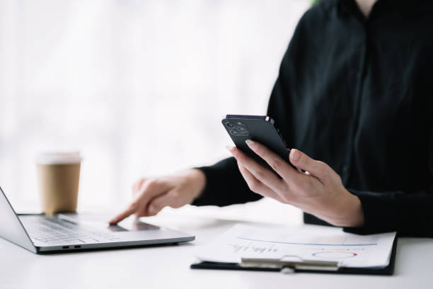 istock Female businessman working with smart phone and laptop and digital tablet computer. 1487707773