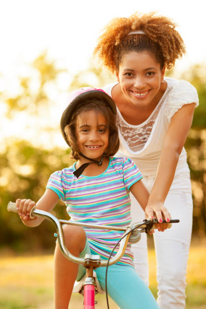 istock Mother Teaching Child to ride a bicycle 148770987
