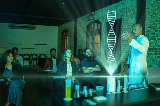 Teacher explaining while showing a holographic DNA image in the classroom