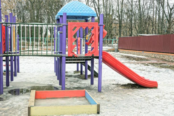 colored plastic buildings with a slide and a square wooden sandbox