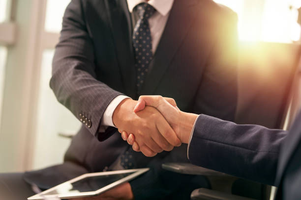 asian business people shaking hands in office stock photo