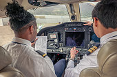 Private jet pilots going through checklist inside the cockpit