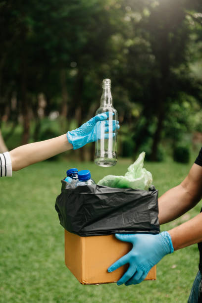 istock people hand holding garbage bottle plastic and glass putting into recycle bag .Clearing, pollution, ecology  concept. 1487713325