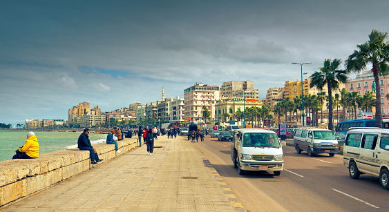 Alexandria, Egypt - February 02, 2023: citizens relax and walk along long embankment in Alexandria