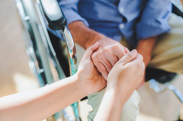 istock High angle view of woman's hands holding man's wrinkled hand 1487718160