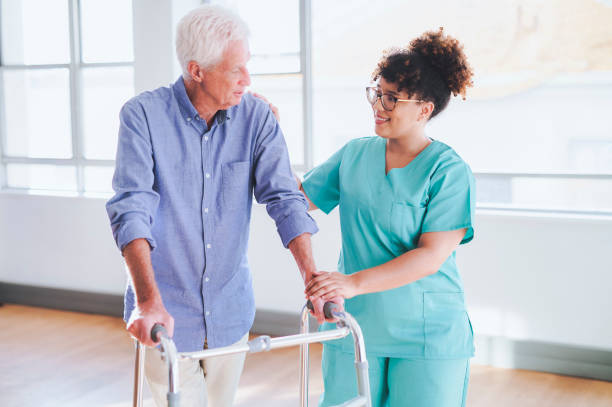istock Senior man using mobility walker talking to female nurse in hospital 1487718204