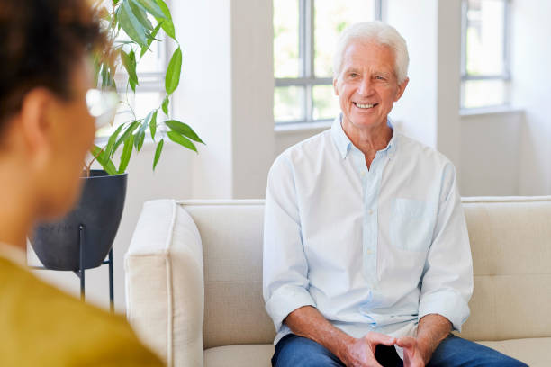 istock Senior man on couch smiling at woman 1487719470