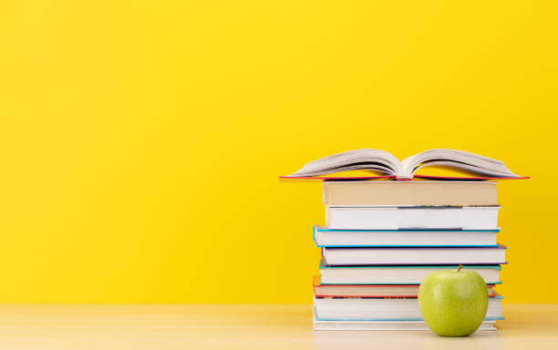 istock Stack of books on desk and apple 1487720477