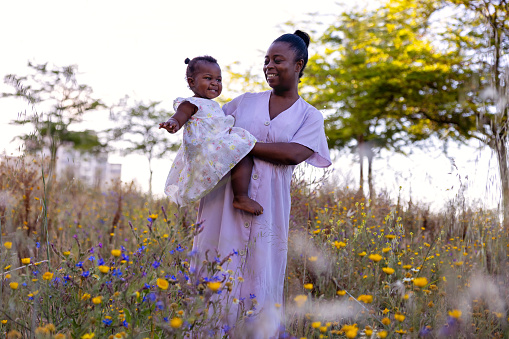 Black Mother and young daughter enjoying the flowers in the Spring
