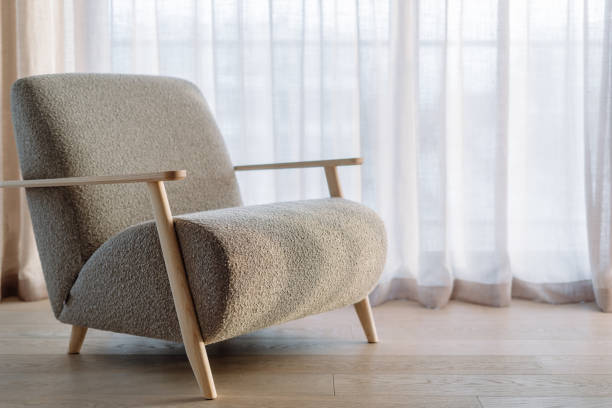istock Soft grey armchair against windows with linen curtains 1487722325