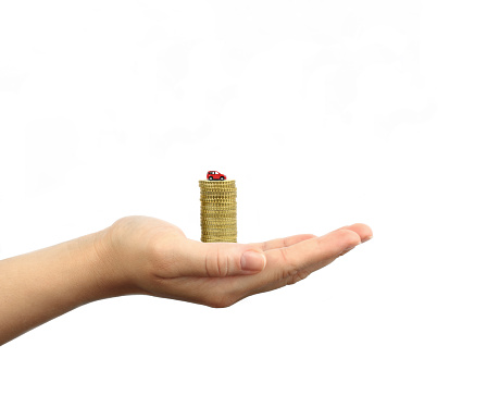 Women Hand holding coins with toy car on white background.Saving Concept