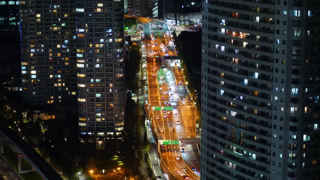 Elevated circular road goes through Tokyo city, high angle shot in night