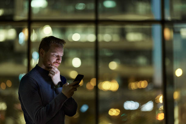 istock Pensive man reading a text message on smart phone in the dark. 1487736150