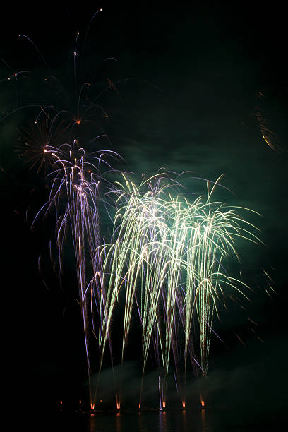 istock Purple and green fireworks on the lake 148773722