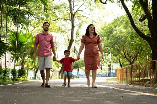 Father, mother and son walking in wooded park