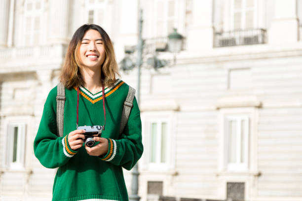 istock Young Asian traveler with camera in city 1487738024