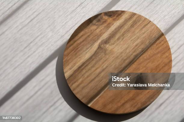 Photo Round Wooden Board On A White Table With The Shadow Of A Window On It  Stock Photo - Download Image Now - iStock