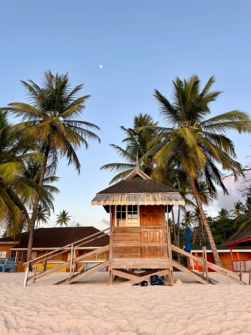 Strand wachter huis bij pigeon baai Tobago tijdens zonsondergang met palmbomen