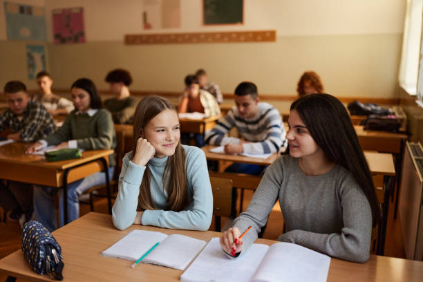 istock Smiling female students talking on a class at high school. 1487741010