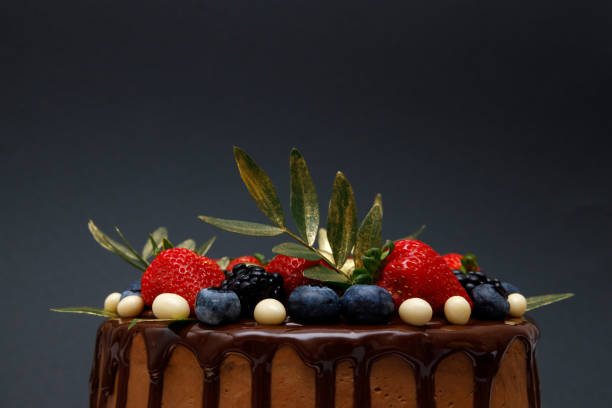 istock cake in chocolate glaze with strawberries, blueberries and blackberries 1487745416