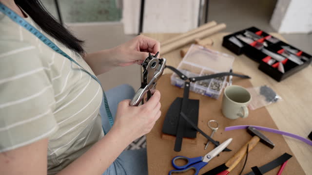 Woman uses tongs to make leather