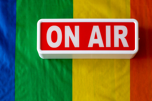 banner or display with the word on air over a gay pride flag