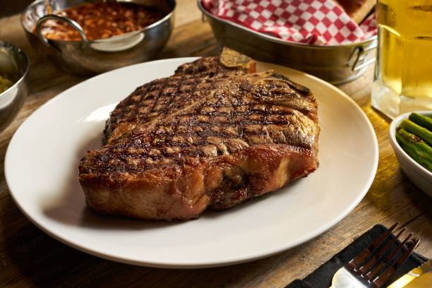 istock Steak served with vegetables on a white plate on a wooden table 1487756665
