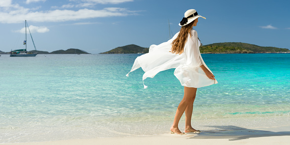 Attractive woman walking with beach cover up on a tropical beach, Scott Beach, St. John