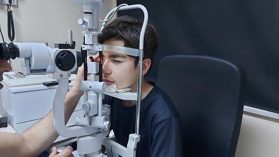 Teen boy having eyesight test on clinic