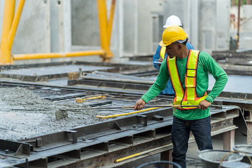 A construction worker is installing the formwork on the construction site.  Concrete rebar. Workers make molds for reinforced concrete from reinforcing bars.