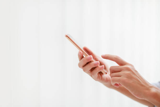 a side view image depicts a woman using a phone against a white background. - fazendo sinal com a mão imagens e fotografias de stock