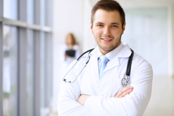 istock Smiling doctor waiting for his team while standing upright 1487763087