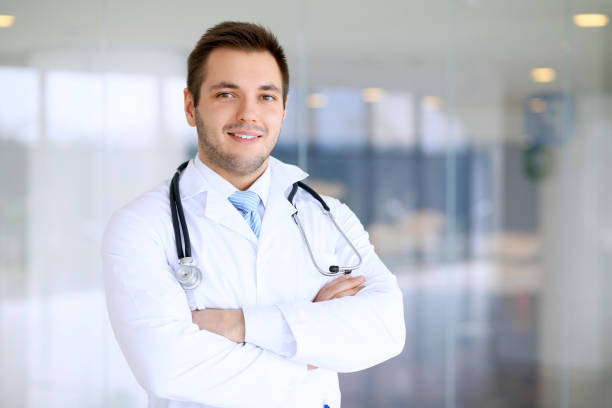 istock Smiling doctor man standing straight in hospital 1487763111