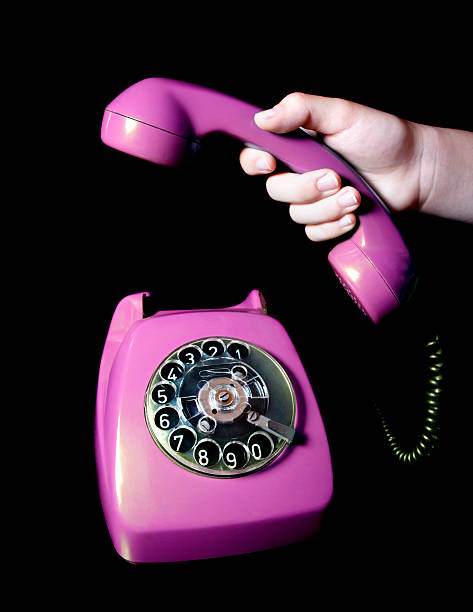 старый телефон, розовый - retro revival telephone human hand toned image стоковые фото и изображения