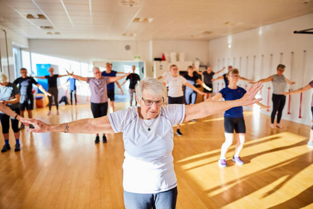 istock Senior woman doing an aerobics class with others at a gym 1487768451