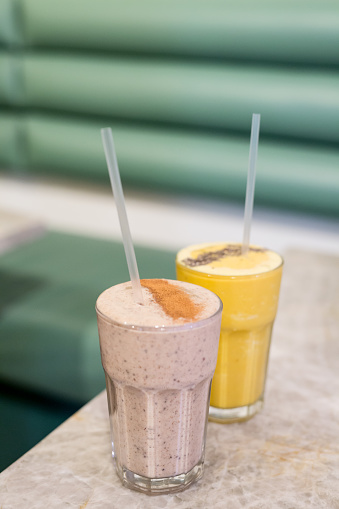 Two smoothies, one chocolate, peanut butter espresso, the other banana, pineapple, turmeric and ginger